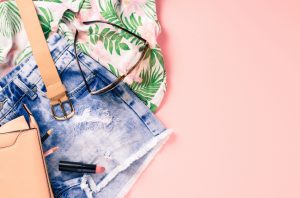 Overhead shot of female casual clothes on pink background