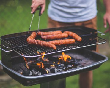 Man som grillar korv.